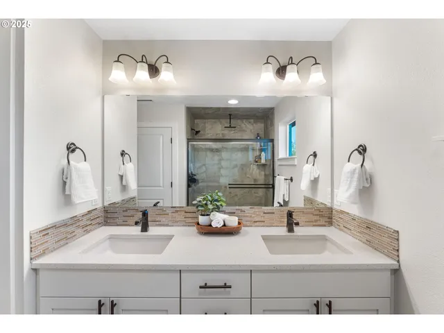 a bathroom with double sink and a mirror