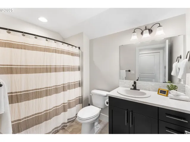 a bathroom with a sink a toilet a shower and a mirror