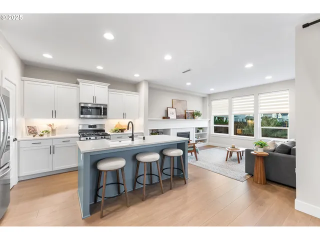 a living room with stainless steel appliances kitchen island granite countertop furniture and a view of kitchen