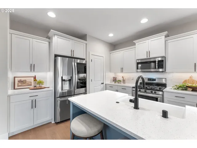 a kitchen with stainless steel appliances a refrigerator stove microwave and sink