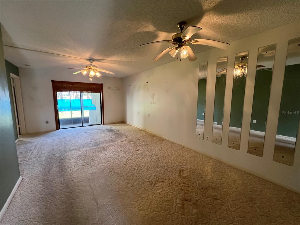 4186 27th Court Southwest, Unit 105 Naples, FL 34116 - Photo 2 of 14 en empty room with windows and fan