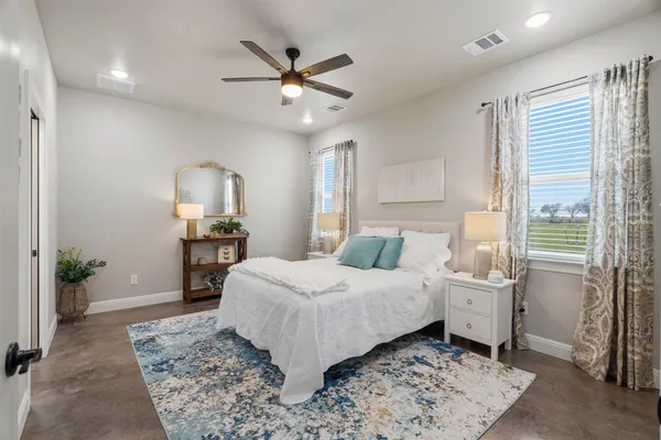 a bedroom with a large bed and a chandelier