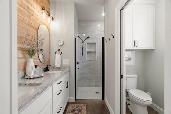 a bathroom with a granite countertop sink mirror toilet and shower