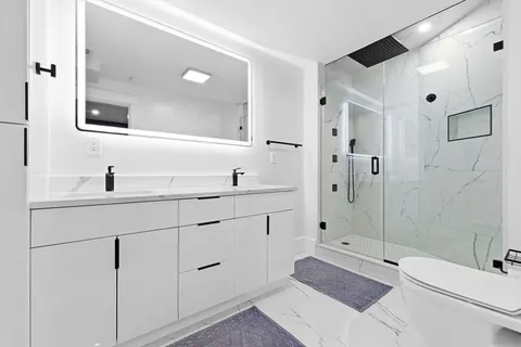 a bathroom with a double vanity sink toilet and shower