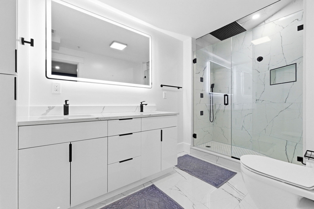 567 Park Street, Unit 2 Boston, MA 02124 - Photo 11 of 20 a bathroom with a double vanity sink toilet and shower