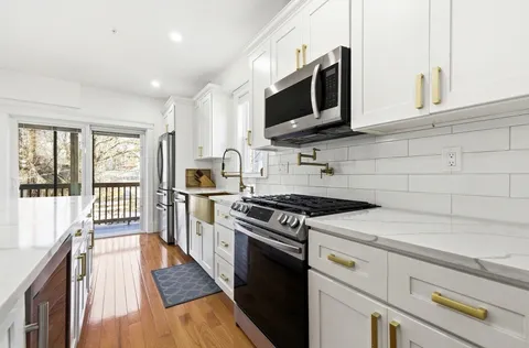 a kitchen with stainless steel appliances a stove microwave and refrigerator