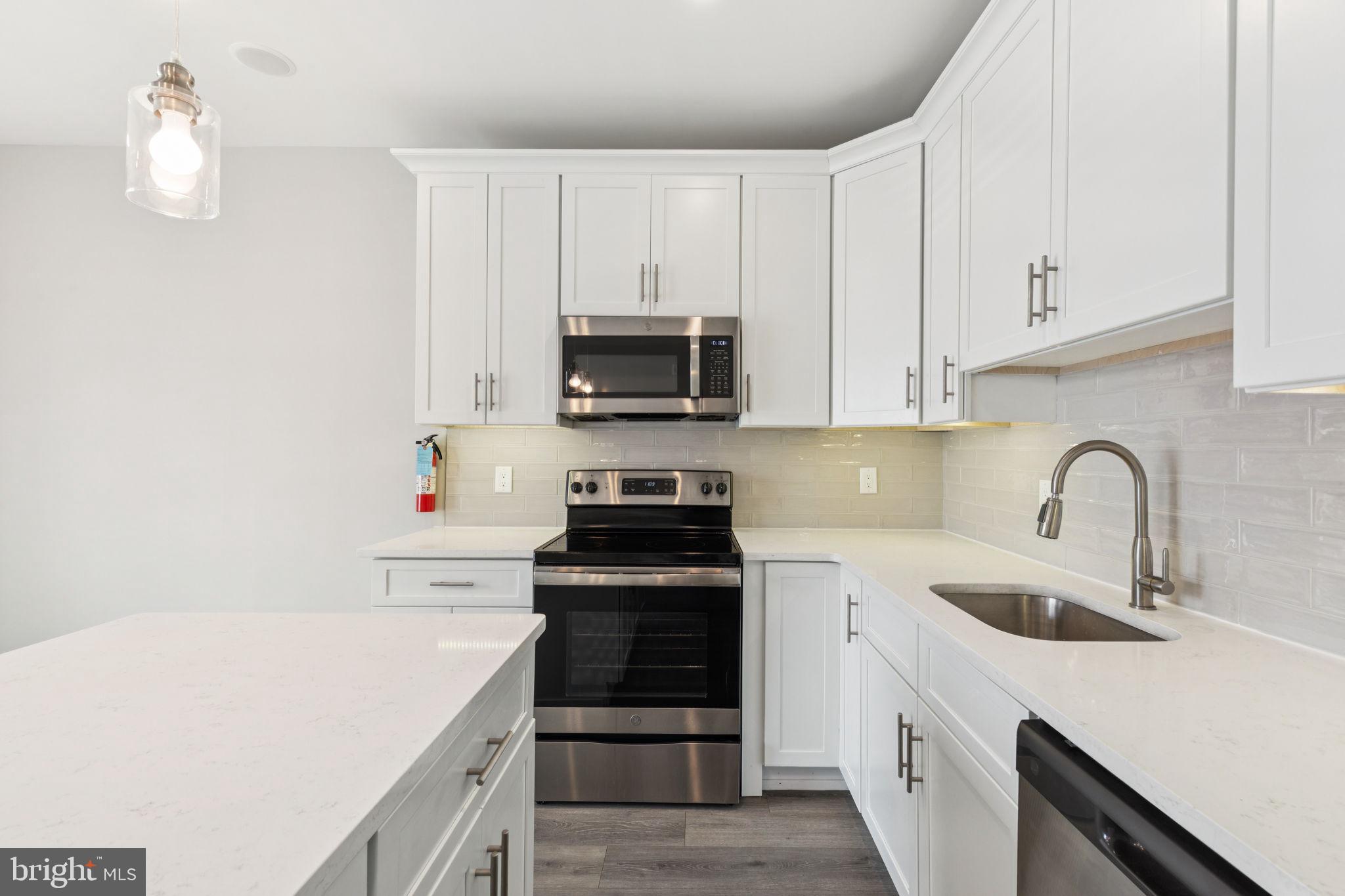 2531 North Front Street, Unit 2 Philadelphia, PA 19133 - Photo 5 of 25 a kitchen with white cabinets and black appliances
