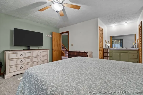 a large bedroom with a bed and a flat screen tv
