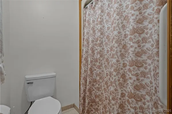 a white toilet sitting next to a shower curtain