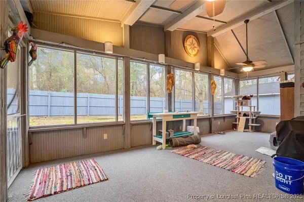 a living room with furniture a flat screen tv and a large window