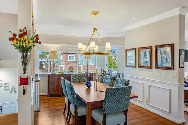 a dining room with furniture potted plants and wooden floor