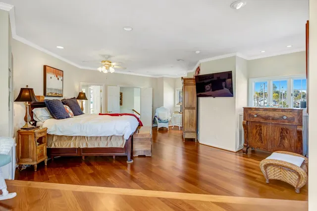 a spacious bedroom with a bed and wooden floor