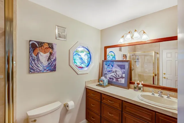 a bathroom with a sink a mirror and a painting on the wall