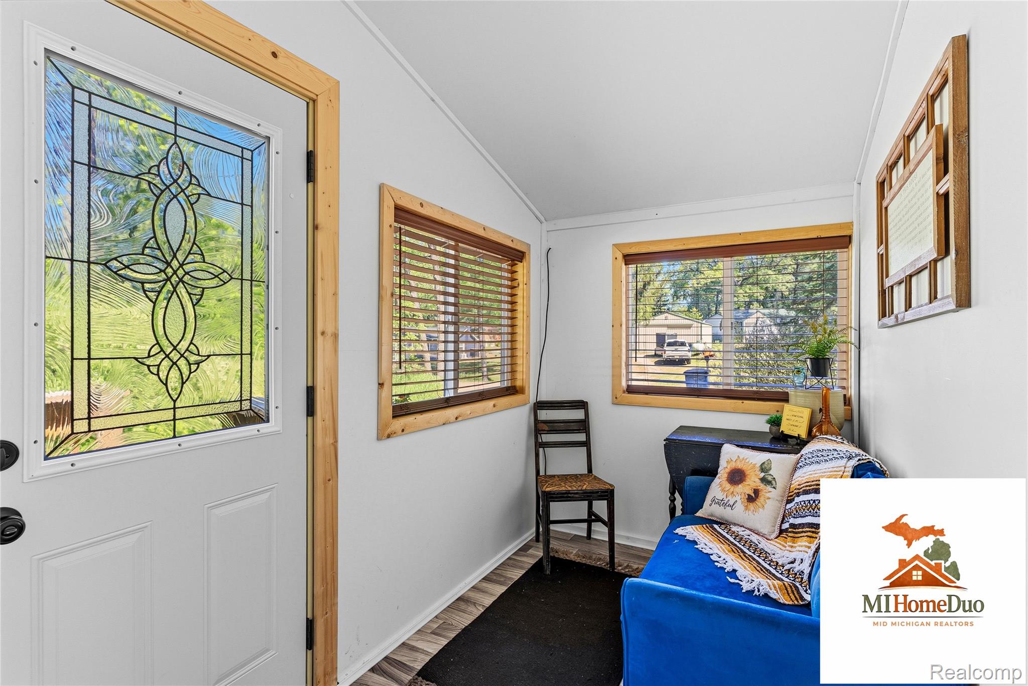 6960 Rumsay Street Harrison, MI 48625 - Photo 16 of 29 Entryway featuring a decorative glass panel door and natural wood trim accents