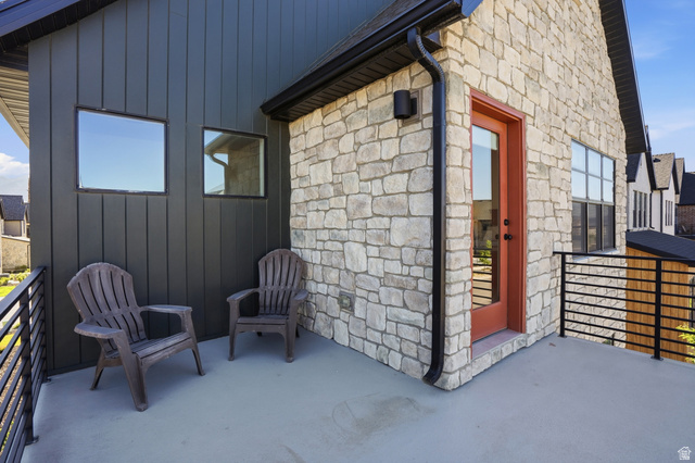 11531 Engelmann Drive Draper, UT 84020 - Photo 27 of 31 Exterior balcony featuring a smooth concrete surface, black metal railing, and a red-orange door