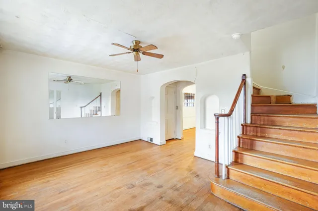 a view of a room with wooden floor and ceiling fan