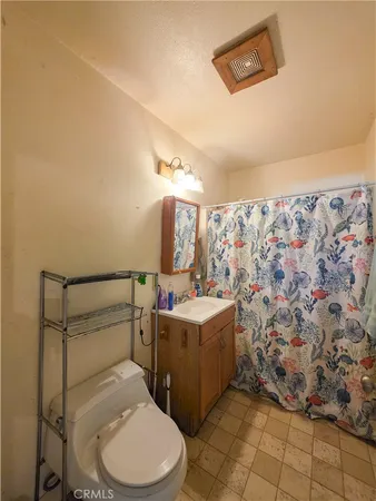 a bed sitting in a bedroom next to a lamp on dresser