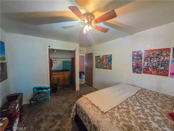 a bedroom with a bed a window and a chandelier