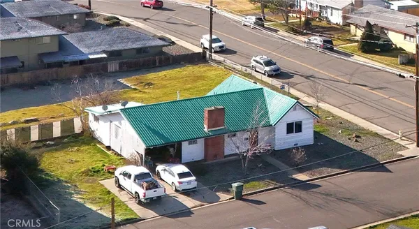 a view of a house with a big yard and a large tree