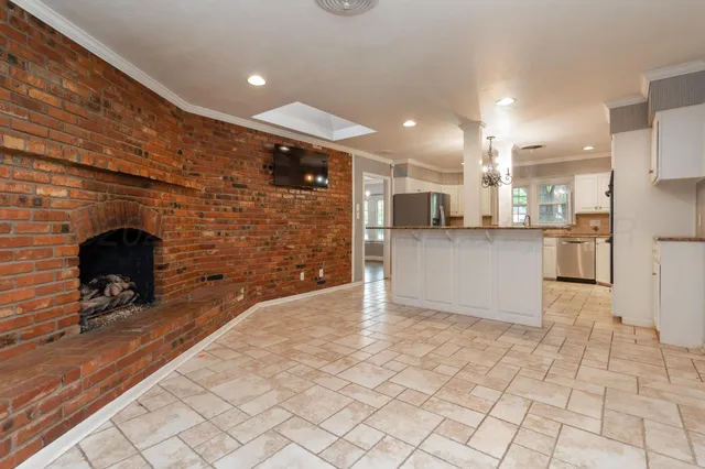 a kitchen with stainless steel appliances kitchen island granite countertop a refrigerator and a stove top oven
