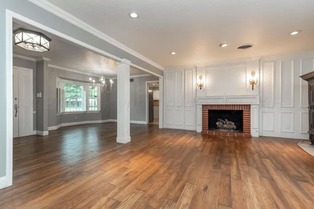 a view of a hallway with wooden floor and a fireplace