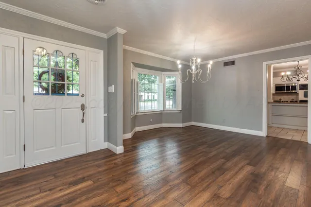 a view of a room with wooden floor and window