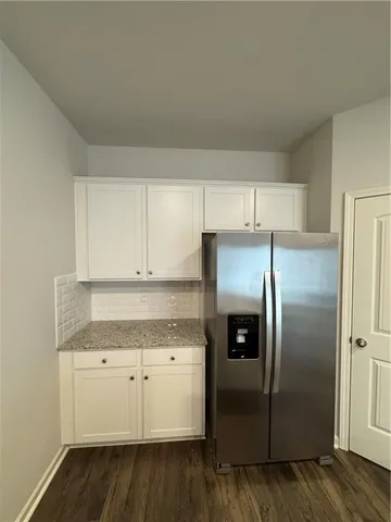 a kitchen with stainless steel appliances granite countertop a refrigerator and a stove