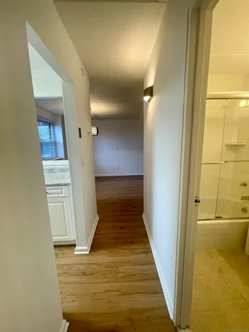 a view of a hallway with wooden floor and staircase