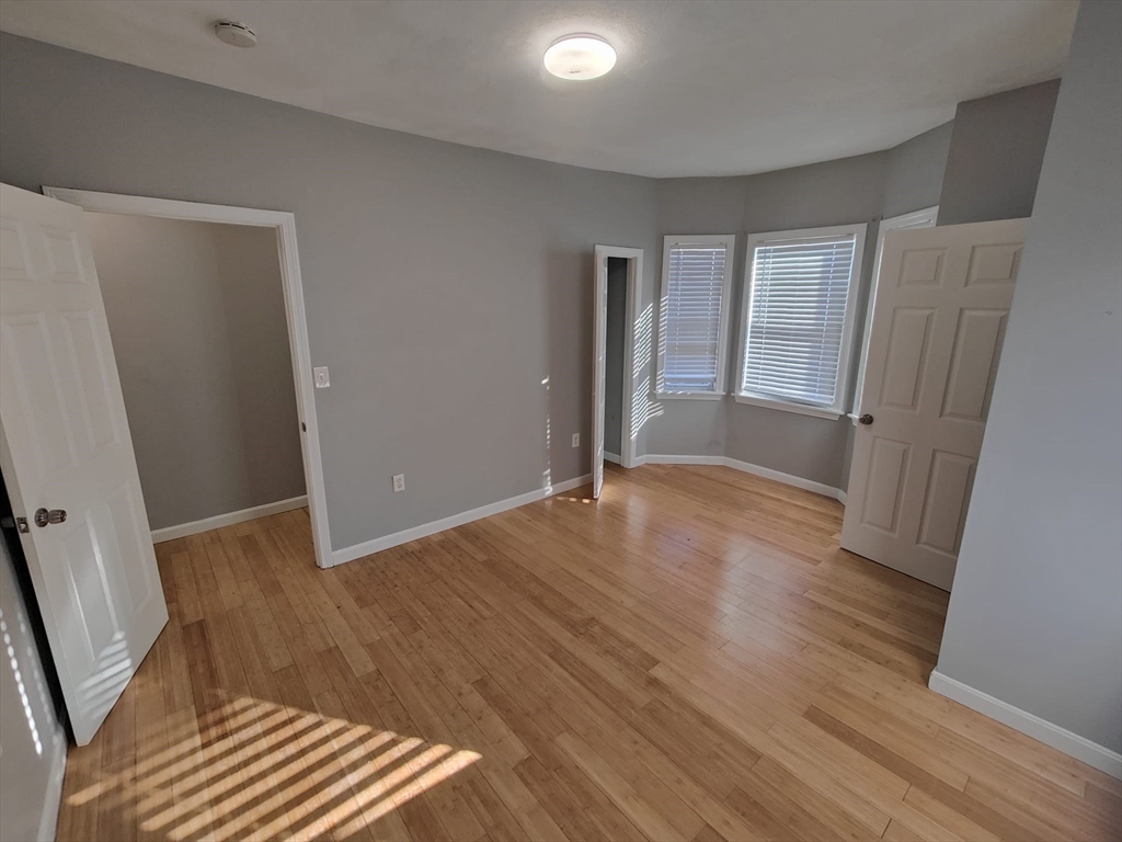 30 Vine Street, Unit 2 Haverhill, MA 01830 - Photo 9 of 13 an empty room with wooden floor and windows