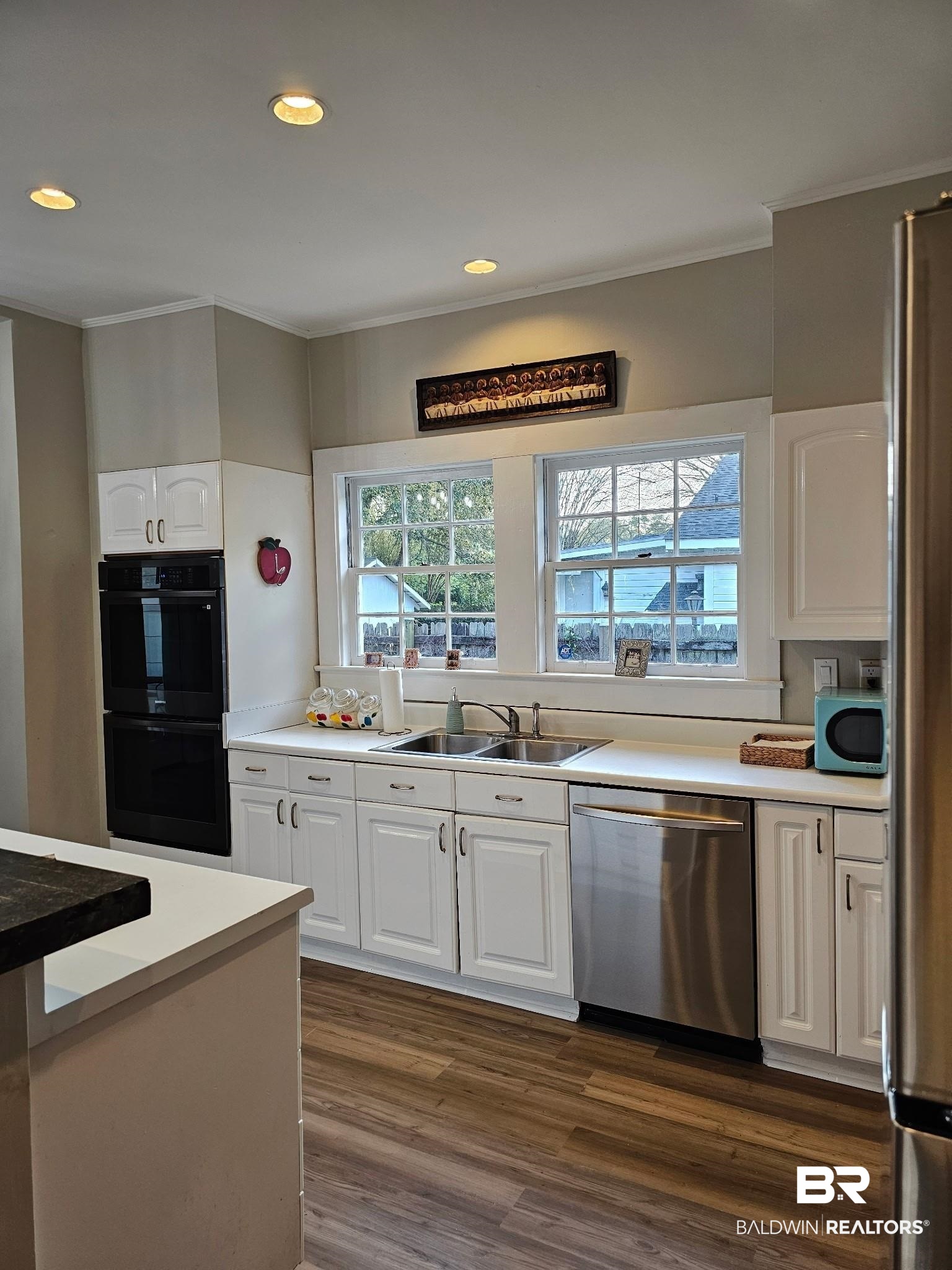 1215 Church Street Mobile, AL 36604 - Photo 9 of 23 Kitchen featuring white cabinetry, ornamental molding, a sink, and appliances with stainless steel finishes