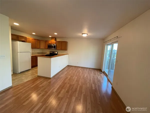 a kitchen with stainless steel appliances a refrigerator and wooden floor