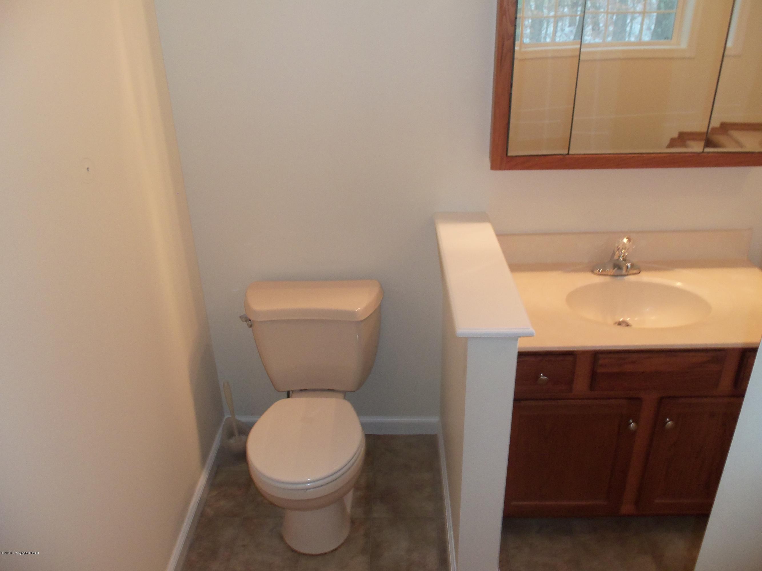 4153 Romeo Road Tobyhanna, PA 18466 - Photo 39 of 41 a bathroom with a toilet a sink and mirror