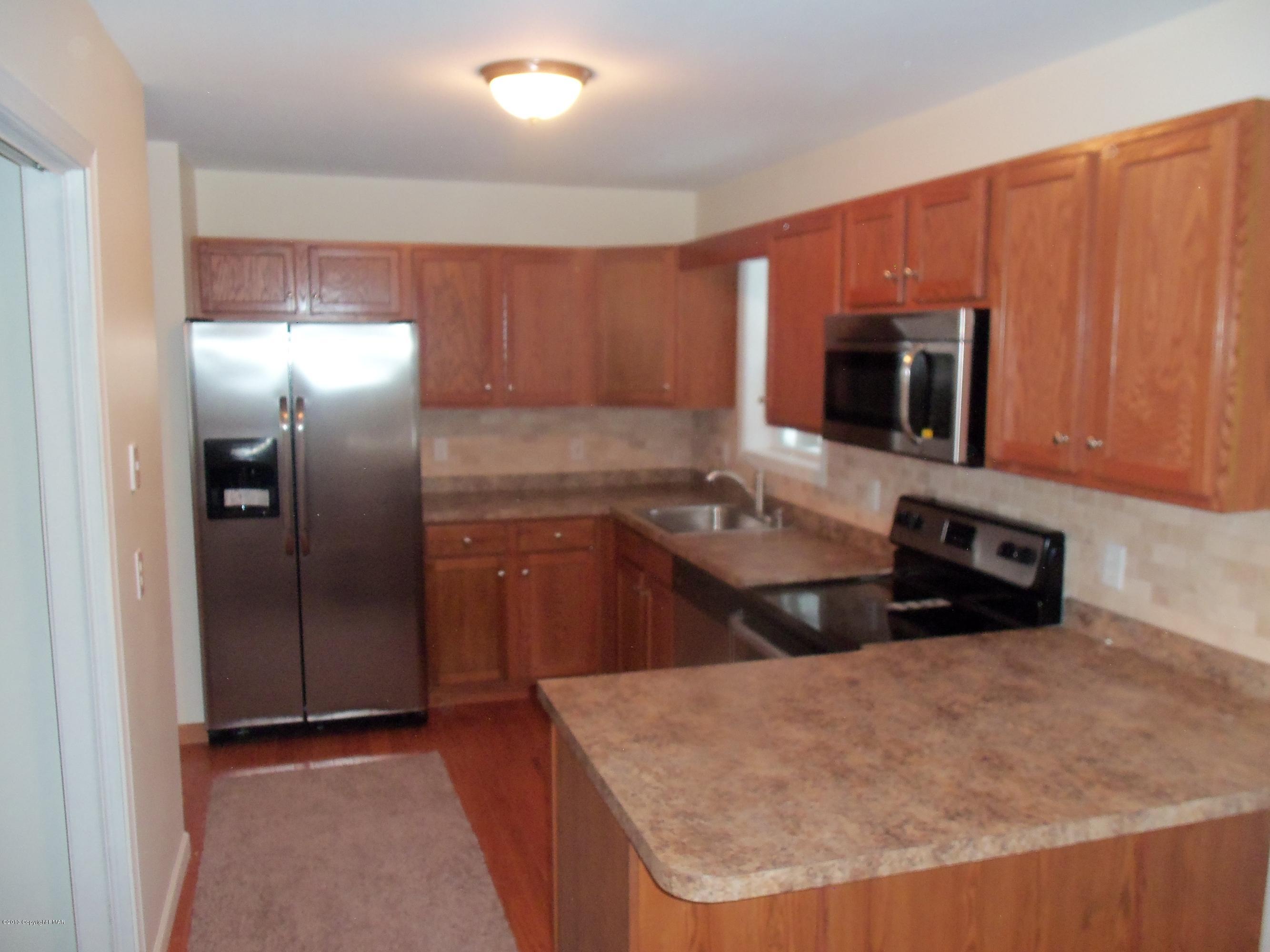 4153 Romeo Road Tobyhanna, PA 18466 - Photo 9 of 41 a kitchen with stainless steel appliances granite countertop a sink a stove and a refrigerator with wooden floor