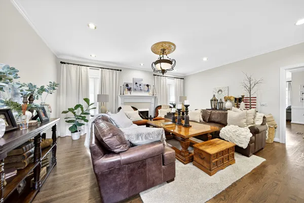 a living room with furniture a chandelier and a dining table