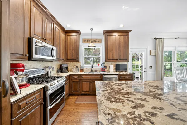 a kitchen with stainless steel appliances granite countertop a stove sink and cabinets