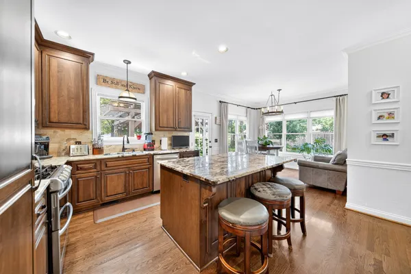 a kitchen with stainless steel appliances granite countertop a sink stove and wooden floor