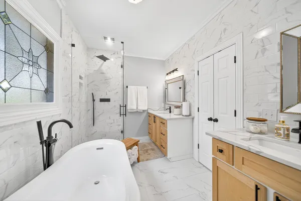 a bathroom with a granite countertop sink mirror and a bathtub