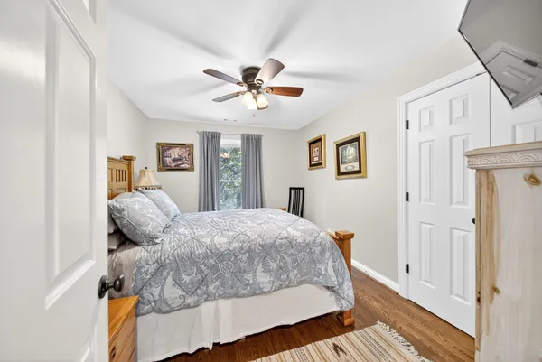 a bedroom with a bed and wooden floor