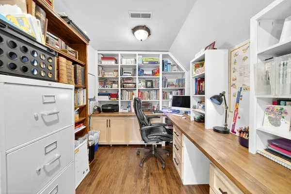 a view of a workspace with furniture and wooden floor