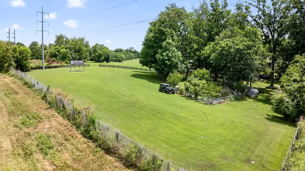 a view of a big yard with swimming pool and green space