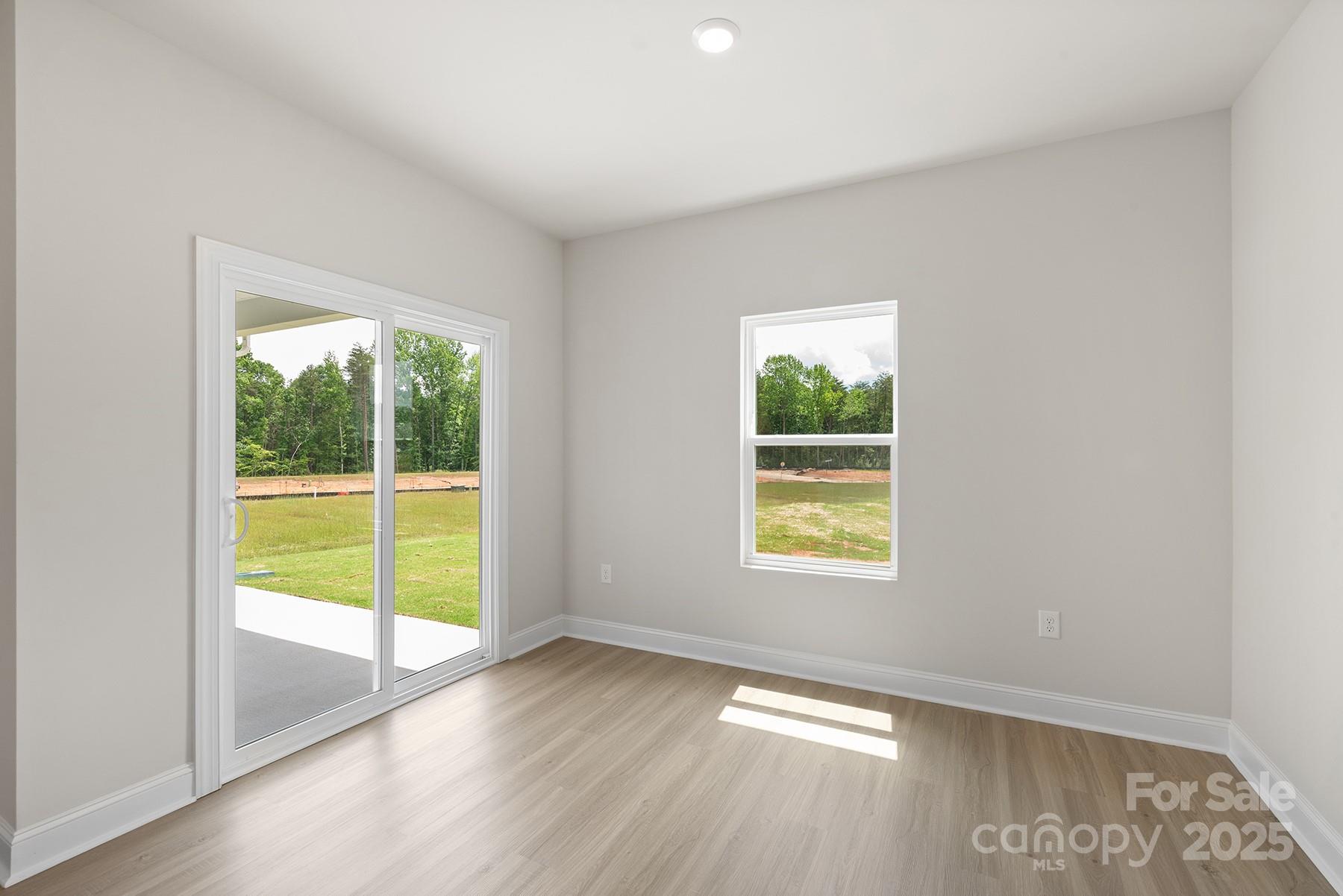 7117 Jerimoth Drive Charlotte, NC 28215 - Photo 8 of 12 a view of an empty room with wooden floor and a window