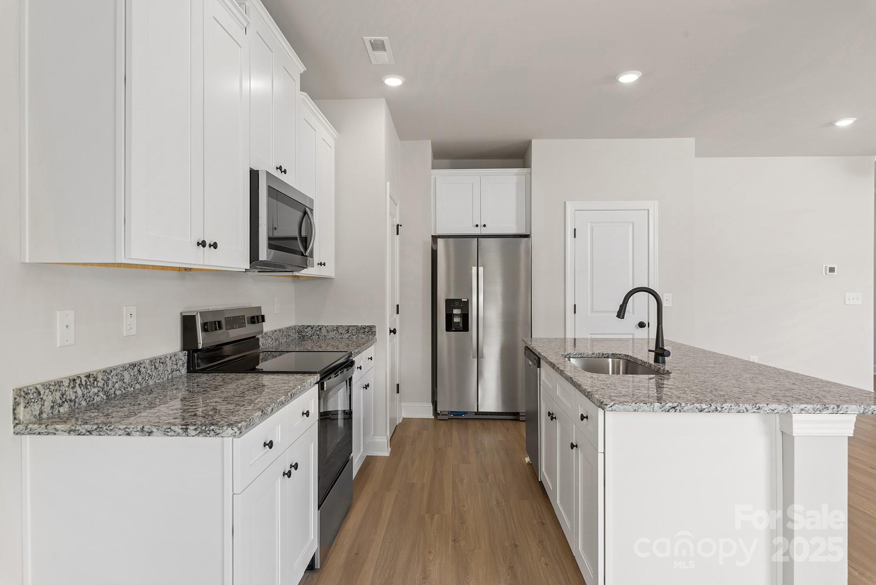 7117 Jerimoth Drive Charlotte, NC 28215 - Photo 9 of 12 a kitchen with stainless steel appliances granite countertop a sink stove refrigerator and cabinets