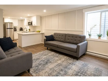 a living room with furniture and kitchen view