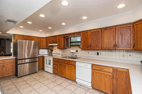 a kitchen with white cabinets sink and white appliances