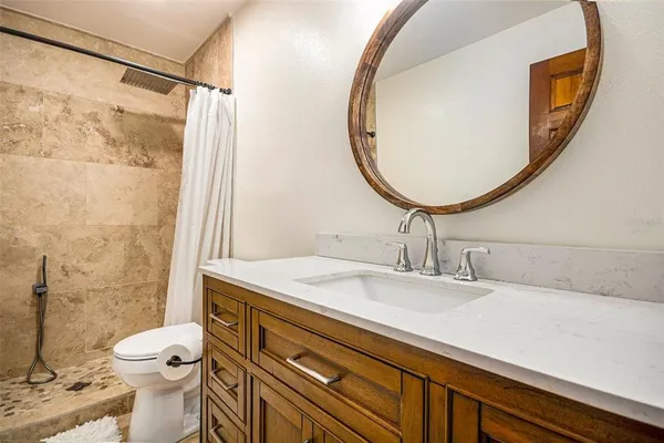 a bathroom with a sink a toilet and a mirror