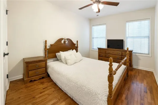 a bedroom with a bed and a flat tv screen on dresser