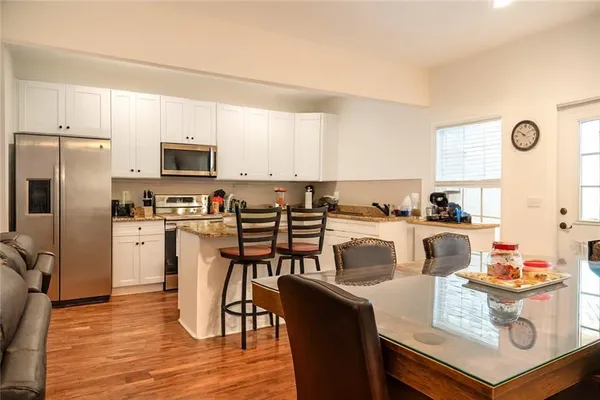 a view of kitchen with microwave stove refrigerator and cabinets