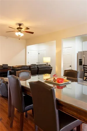 a dining hall with stainless steel appliances a dining table and chairs with wooden floor