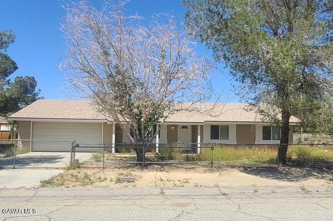 16549 Mossdale Avenue Lake Los Angeles, CA 93535 - Photo 1 of 23 a front view of a house with a dirt yard and a tree