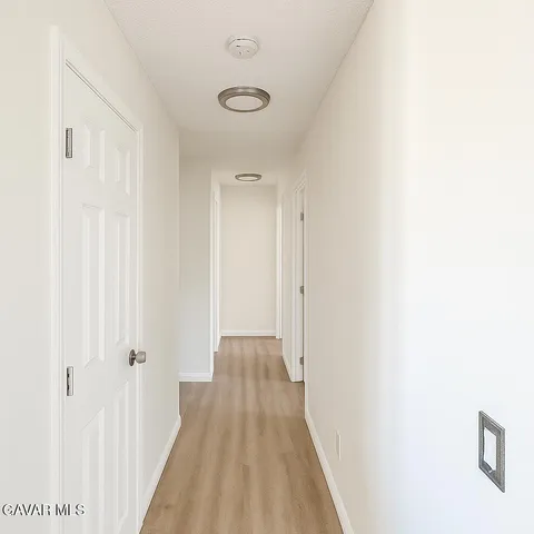 a view of a hallway with wooden floor
